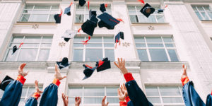 High school graduates who are ready for college and throwing their caps in the air in celebration.