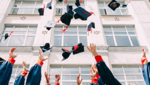 High school graduates who are ready for college and throwing their caps in the air in celebration.