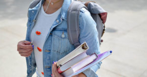 A student holding books and ready for the first day of school.